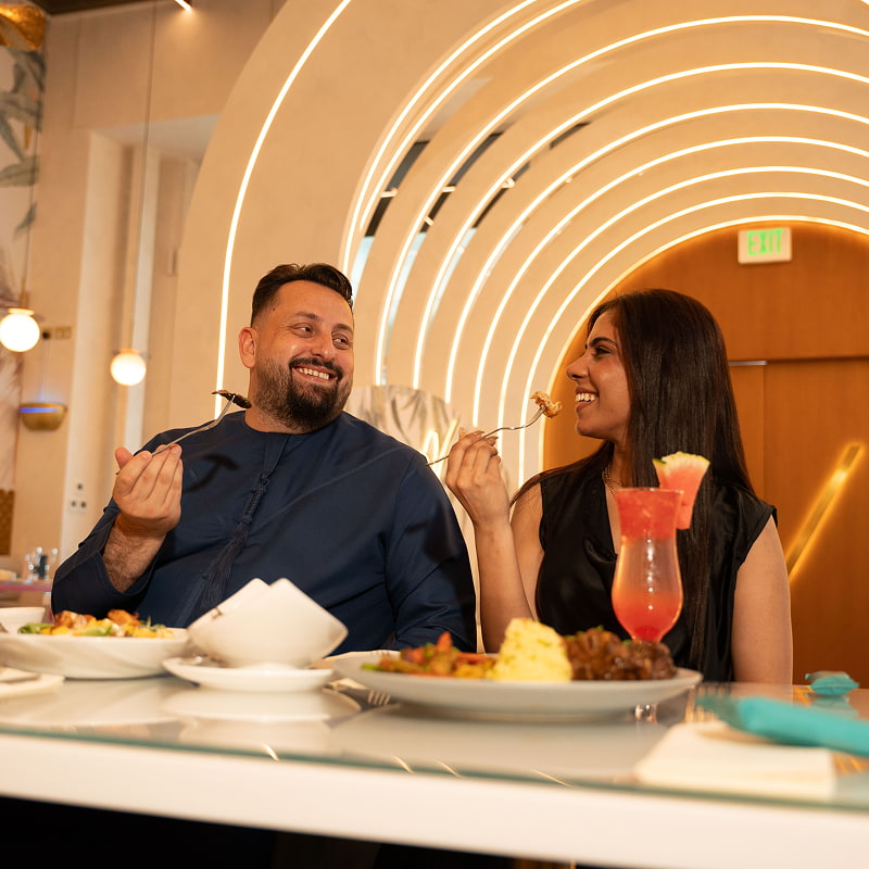 A man and a woman enjoying food and looking at each other