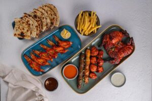 Different types of meat dishes, with sauce, fries, and chappati