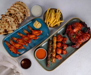 Juicy grilled chicken served on a rustic plate with fresh herbs,french fries, and a side of bread.