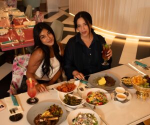 two Woman having food, African food in a restaurant, smiling and enjoying a meal.